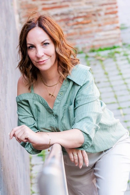 Ramona Leis - Pädagogin für Mindset-Entwicklung - Frau lehnt lässig an einer Wand